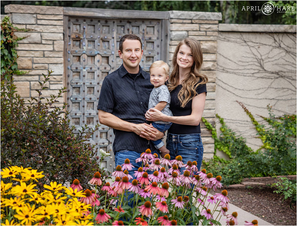 A cute blonde boy is photographed with mom and dad for his first birthday photos at Denver Botanic Gardens