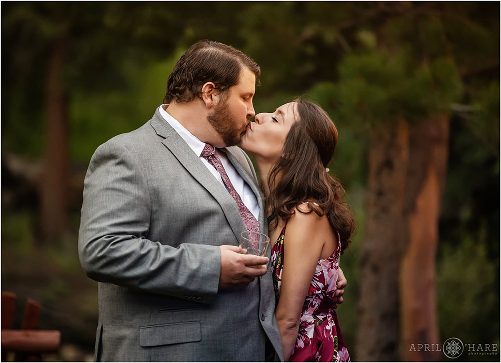 Candid photo of a couple kissing while enjoying an outdoor wedding reception at Estes Park Condos in Colorado