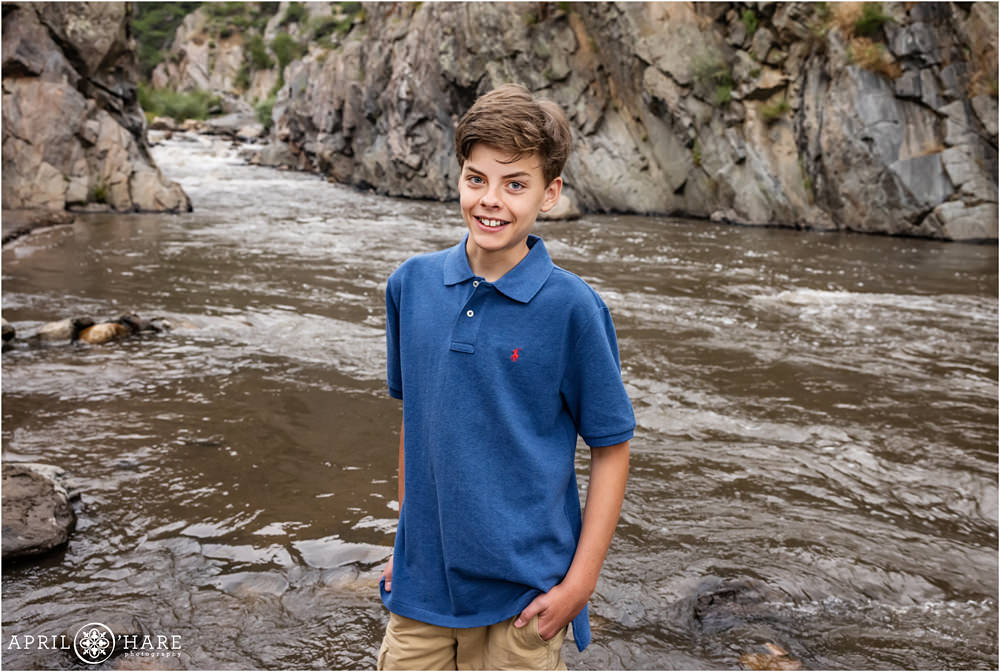 Teen boy smiles while standing in front of the river at Viestenz-Smith Mountain Park