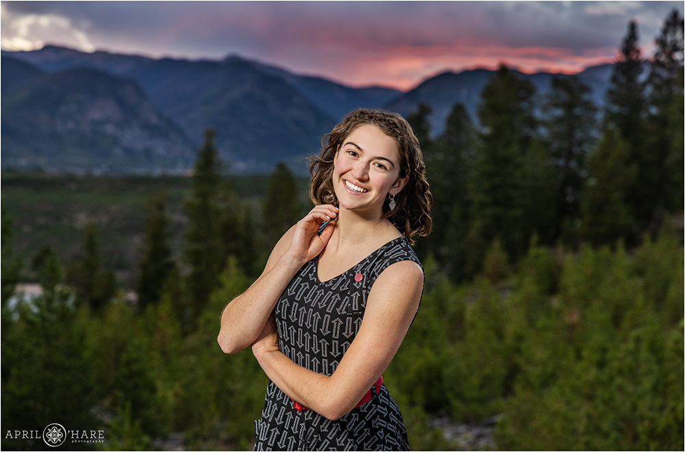 High school senior girl poses at Sapphire Point at sunset with a pretty mountain backdrop