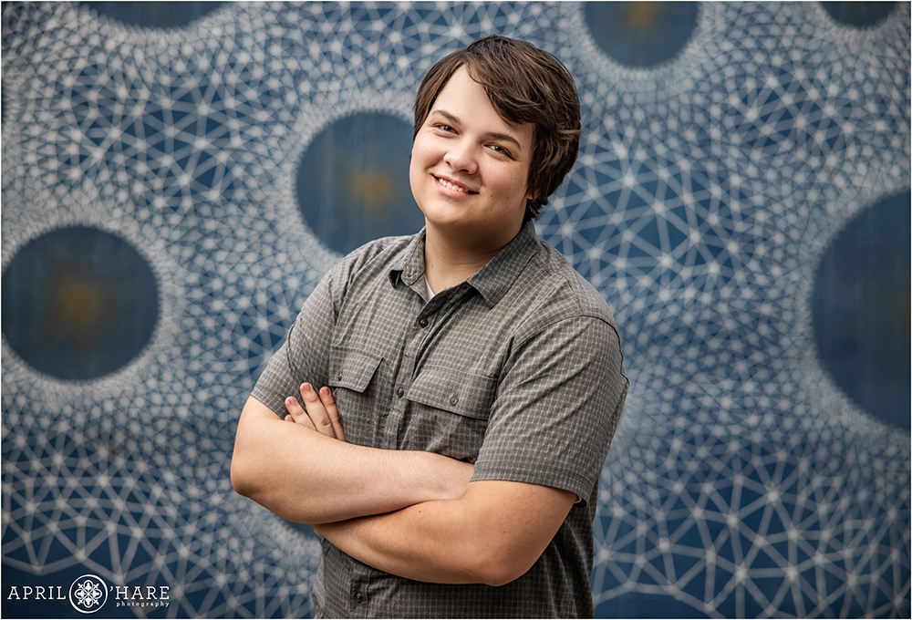 Senior boy yearbook session in front of a blue and white geometric mural painted by Gemma Danielle in Denver