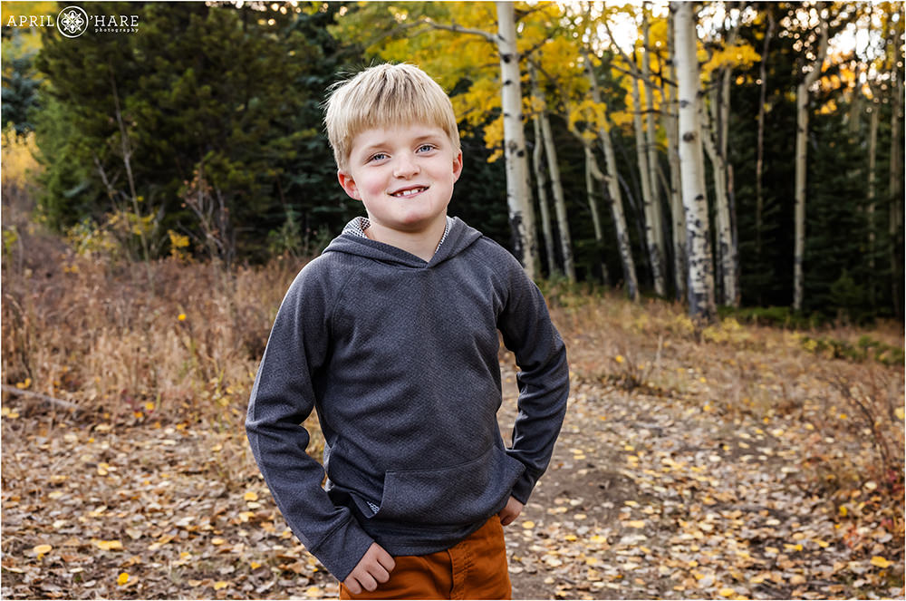 Young blonde boy smiles at his family photography session in Evergreen Colorado