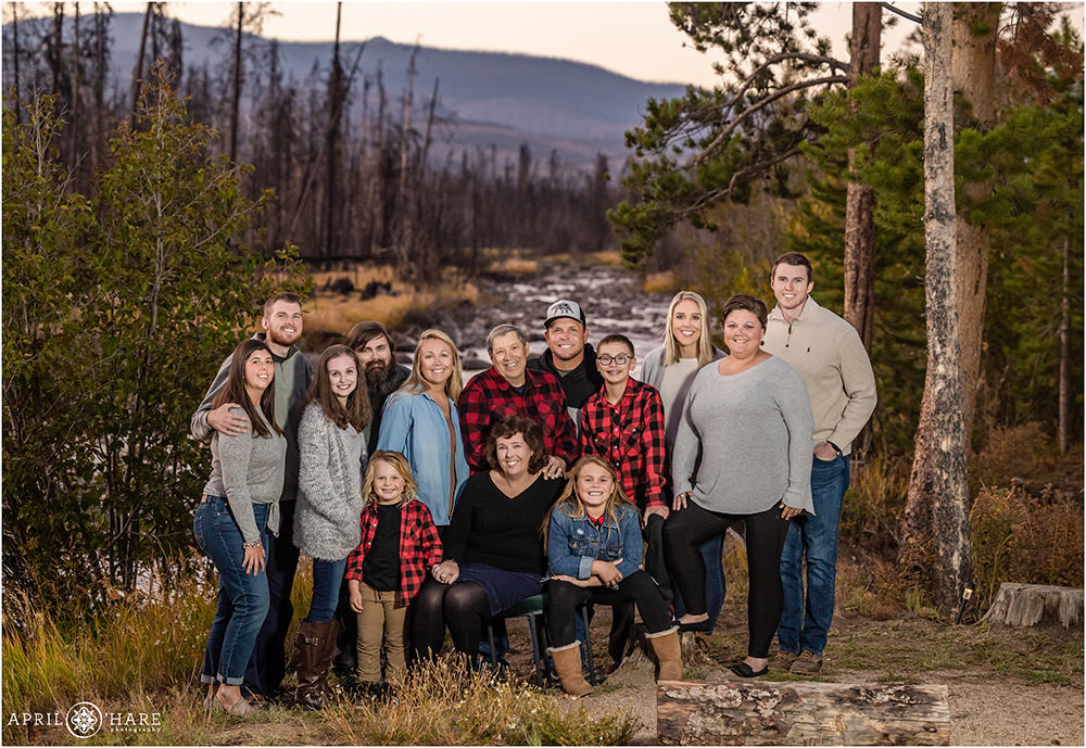 Large Extended Family Wearing Red Buffalo Check flannel and shades of gray pose in front of the Colorado River in Grand Lake