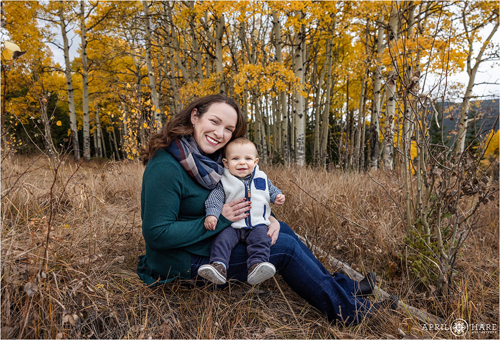 A mom with her cute smiling 8 month boy in the fall color of Evergreen Colorado