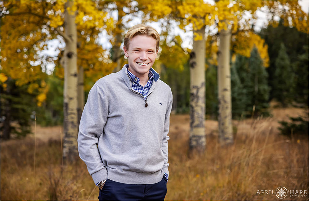 Senior boy cracks a smile with pretty fall color backdrop in Evergreen Colorado