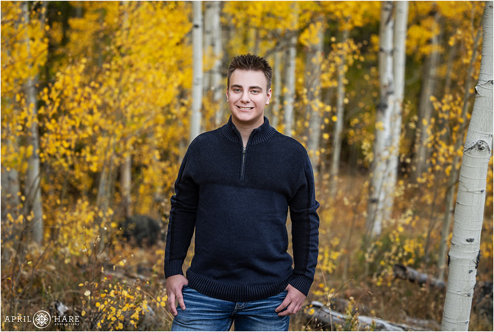 High school senior boy with a pretty gold fall color aspen tree forest in Frisco Colorado