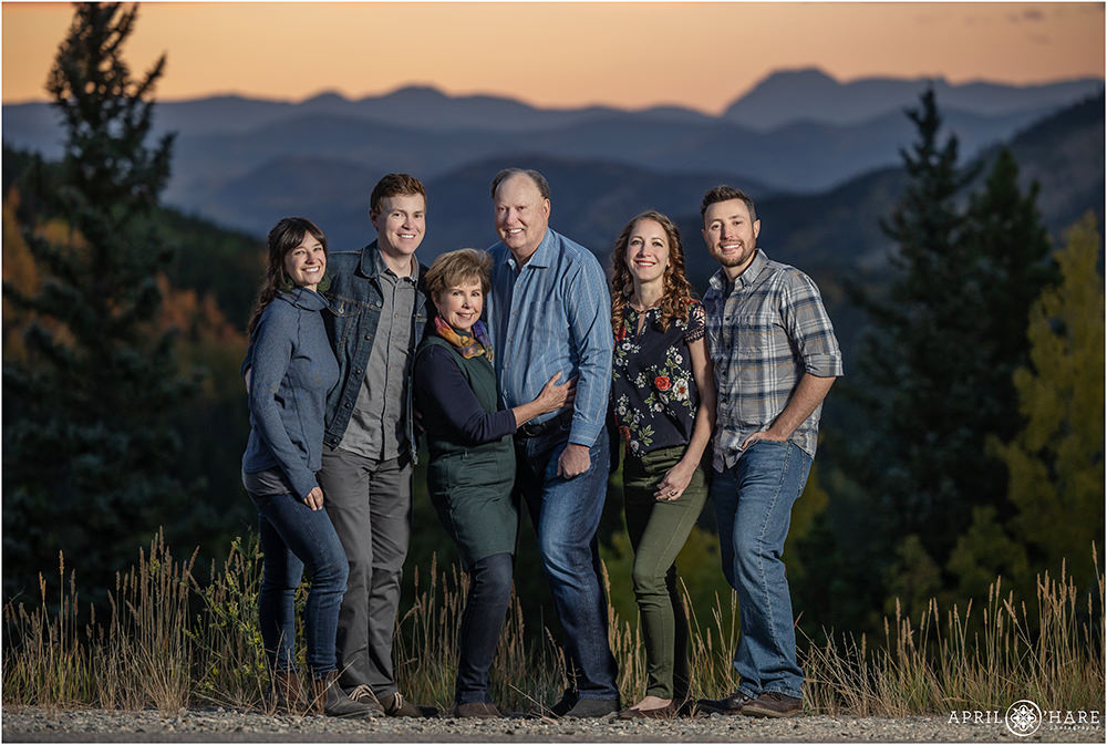 A beautiful sunset family portrait with a layered blue mountain backdrop in Evergreen Colorado