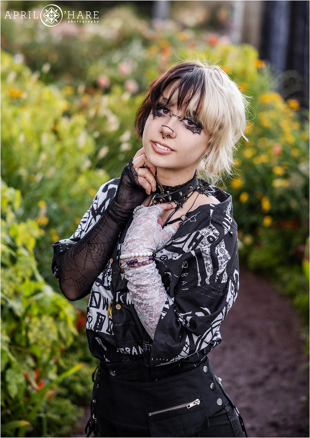 Beautiful senior girl wearing black and white clothes poses in a colorful garden at Denver Botanic Gardens