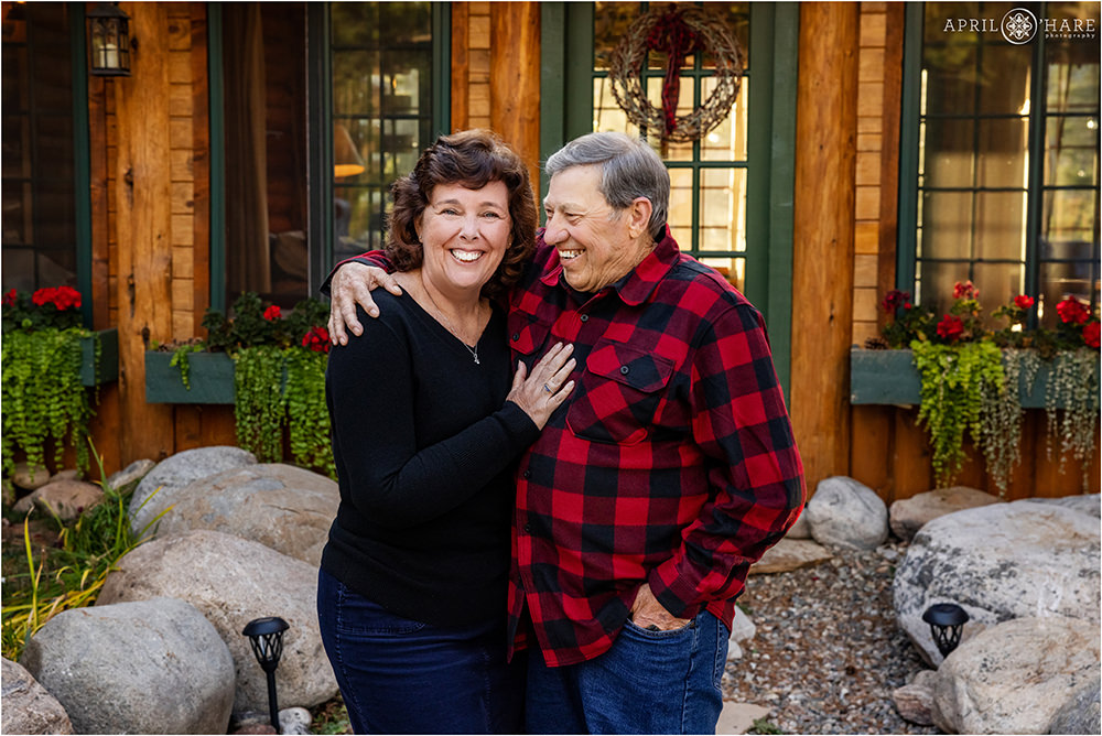A couple laugh together at their family photography session at a private Colorado mountain home in Grand Lake