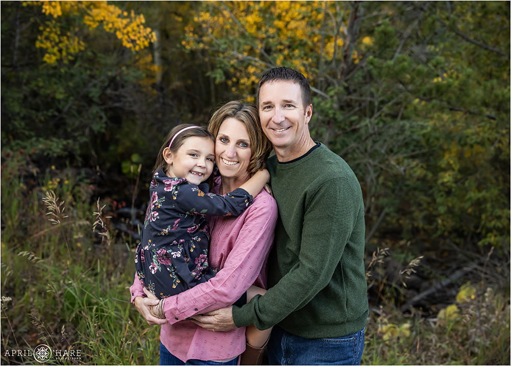 Sweet family of 3 snuggling up with some fall color in the backdrop near Meadow Creek Trailhead in Frisco Colorado