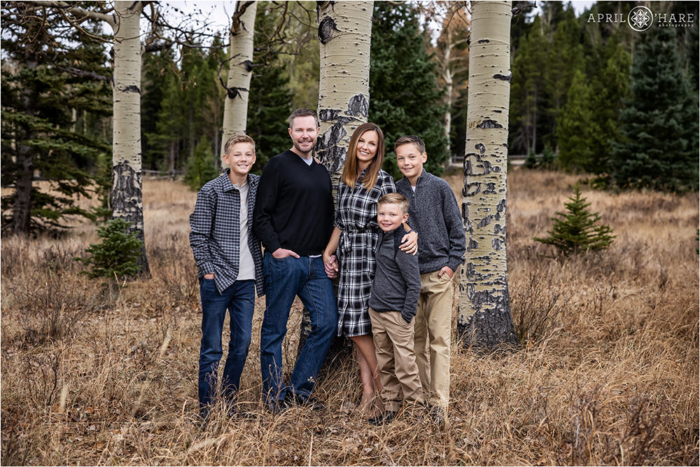 Beautiful family with 3 boys pose in an aspen tree mountain meadow in Colorado