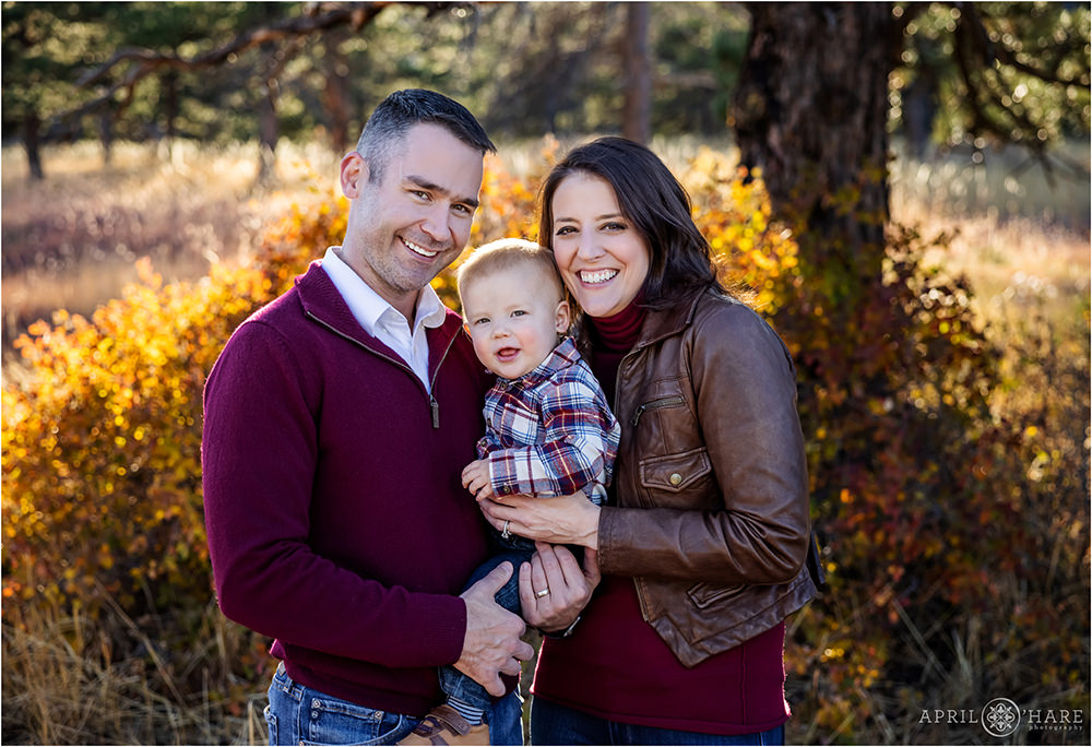 Pretty fall color backdrop for a family portrait with a sweet baby boy wearing plaid at Shanahan Ridge Trailhead in Boulder CO