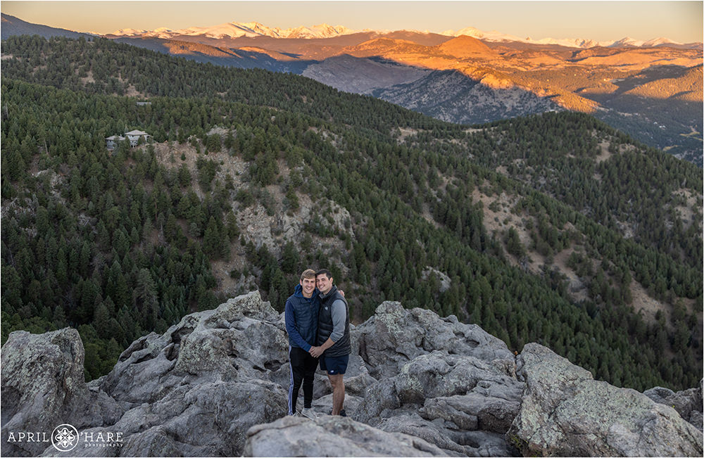 Cute couple pose for a portrait in front of a sunrise mountain backdrop in Boulder