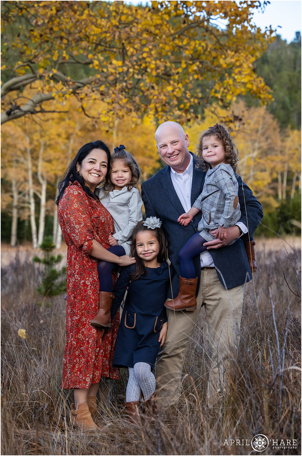 Beautiful family of 5 fall color photo in an Evergreen Colorado meadow with aspen trees