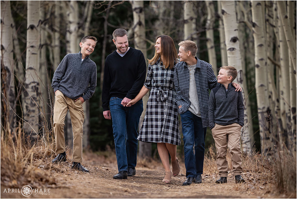 Cute photo of a family of 5 walking down a path with aspen tree backdrop in Colorado