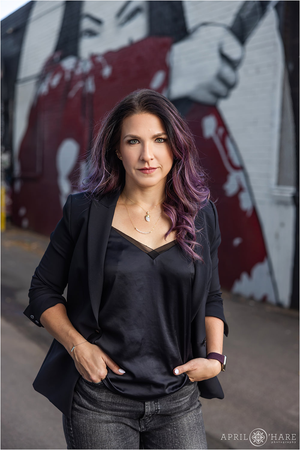 Gorgeous woman with a serious business look with purple hair in an alleyway in North Denver
