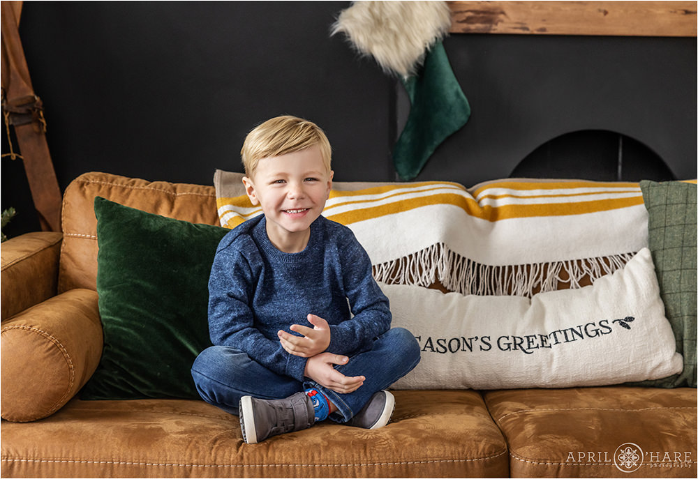 A sweet boy poses for a holiday themed family photoshoot in a studio in Denver