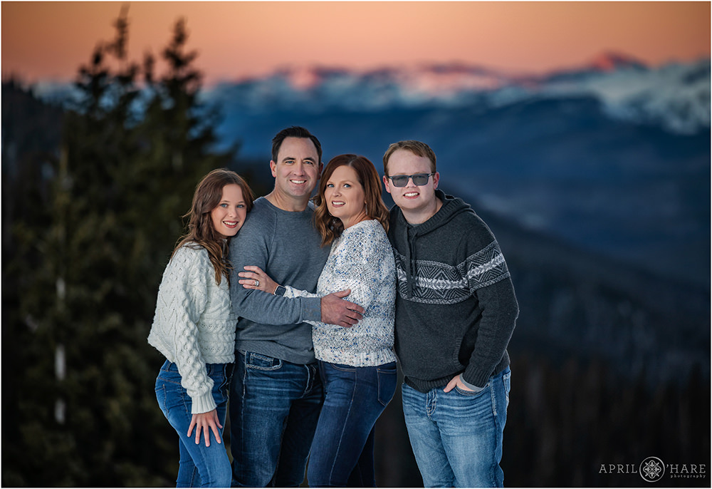 Family of Four Wearing Blue are photographed during winter at Berthoud Pass near Winter Park