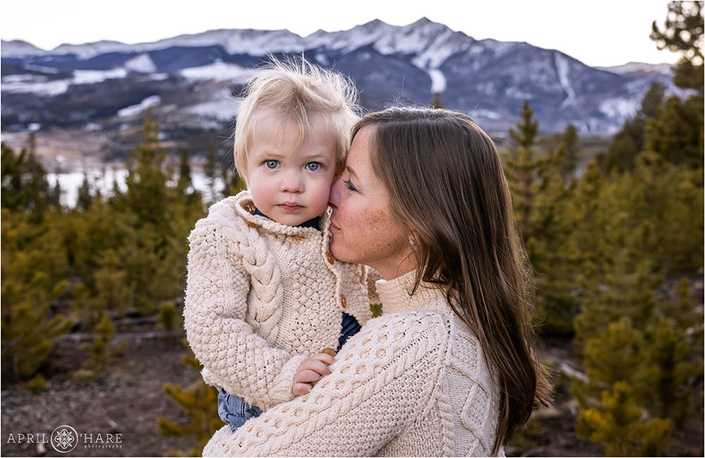 A mom snuggles her son with his cute crazy hair in front of a pretty mountain view at Sapphire Point in Colorado