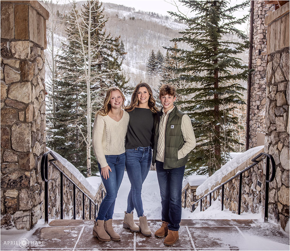 Three teenage siblings pose for a picture at their Colorado family photography session at their hotel in Beaver Creek Colorado