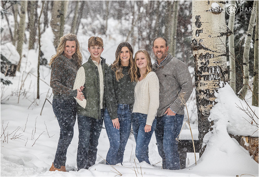 Winter snowstorm family photo with a pretty aspen tree in Beaver Creek Colorado