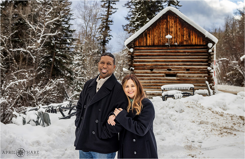 Gorgeous Winter Couples Photo in the Snow with a cute rustic cabin in the backdrop in Beaver Creek Colorado