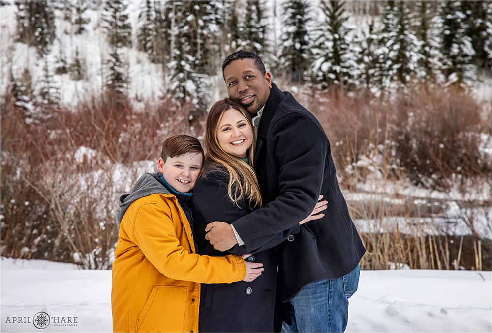 Sweet Cuddly Family Photo in a pretty winter wonderland scene near the Walking Mountains Science Center in Avon Colorado