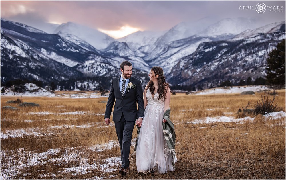 Beautiful cold winter wedding portrait with lovely mountain sunset backdrop at Rocky Mountain National Park in Colorado