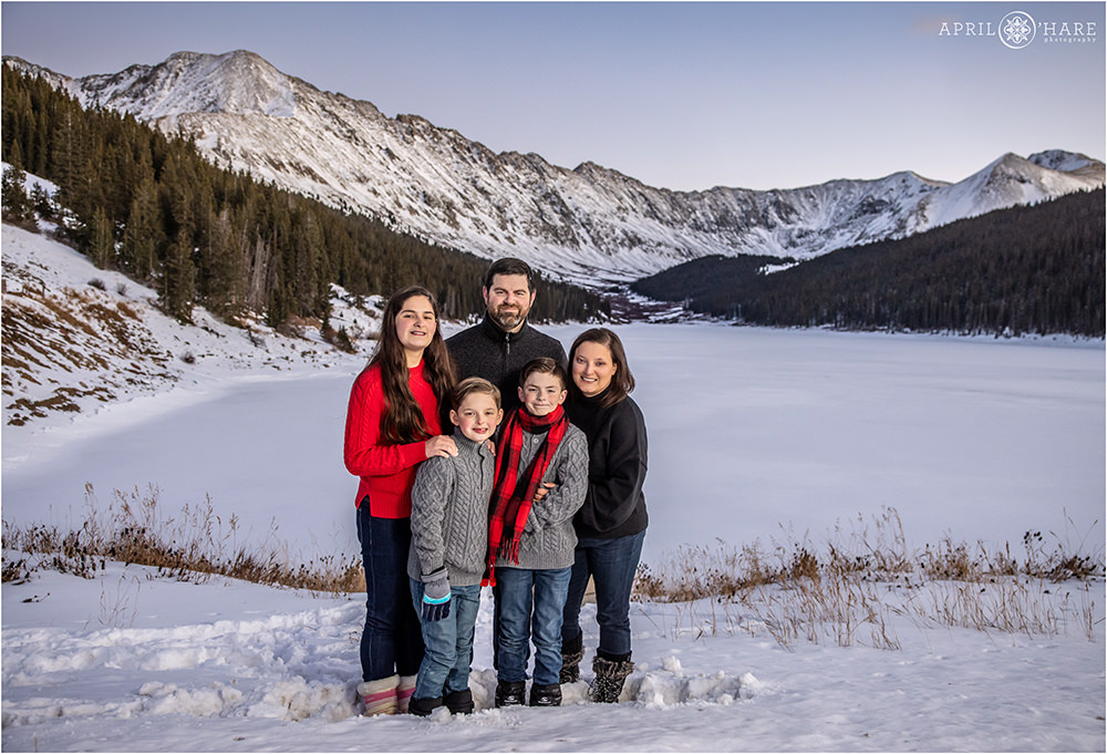 A beautiful winter family portrait in front of the stunning mountain views at Clinton Gulch Dam Reservoir in Colorado