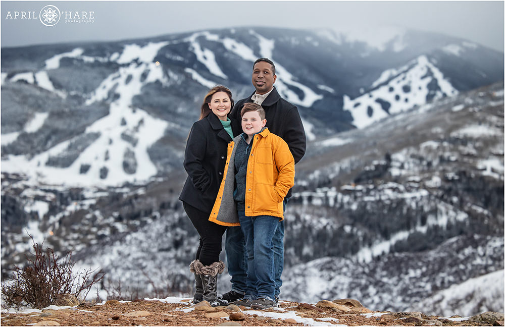 Full length portrait of a family of 3 standing in front of Beaver Creek Ski Resort in Colorado during winter