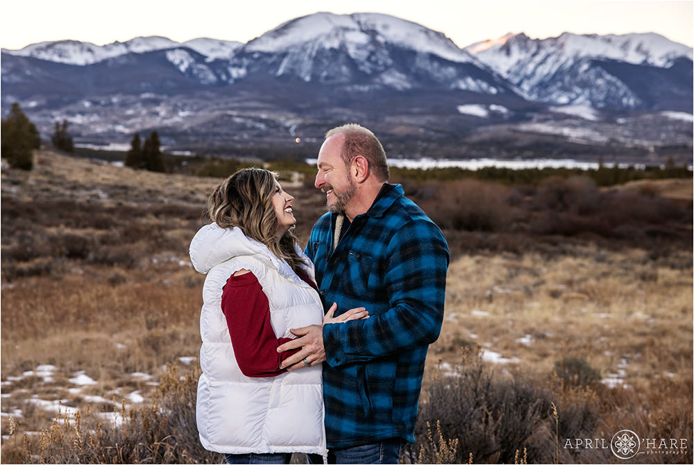 Couple gaze into each other's eyes with Buffalo Mountain in the backdrop on a cold winter day in Summit County