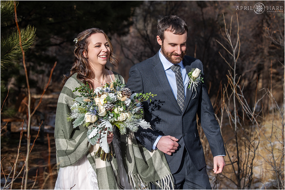 Bride and groom walk into their outdoor winter wedding ceremony together at Romantic Riversong Inn in Colorado