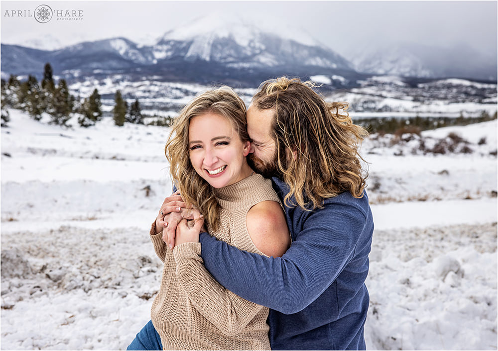 Couple snuggles in the snow during their winter family portraits in Colorado