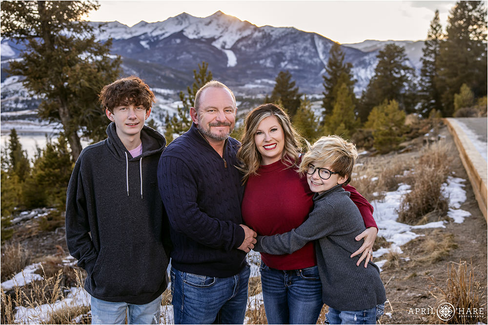 A cute family of four with two sons pose for a mountain photo together at Sapphire Point