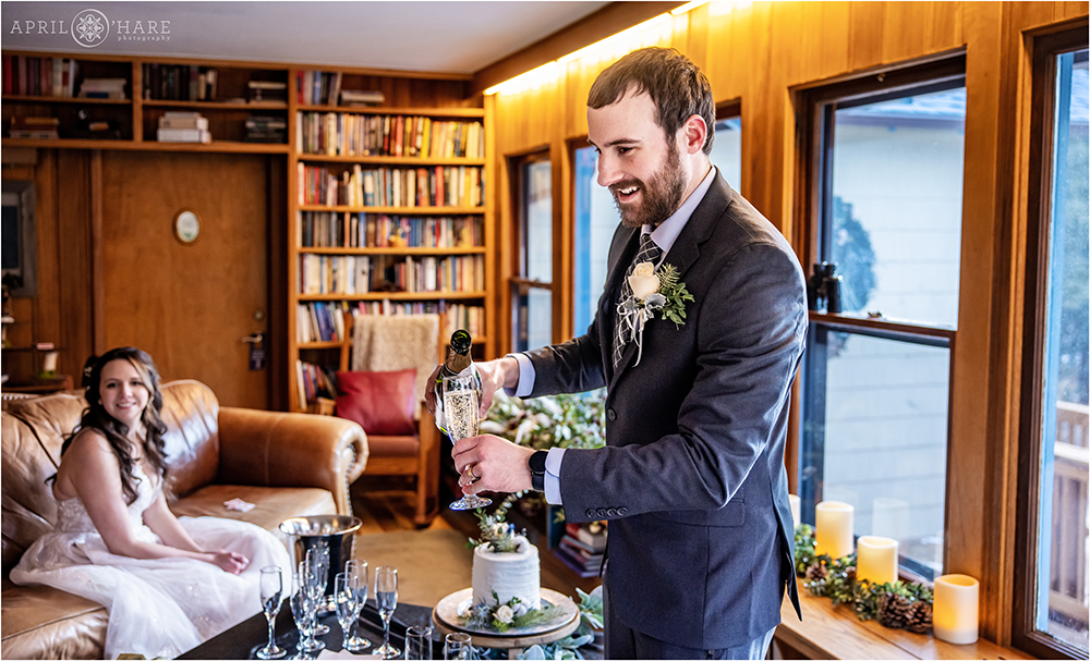 Groom pours some champagne inside Romantic Riversong Inn in Estes Park
