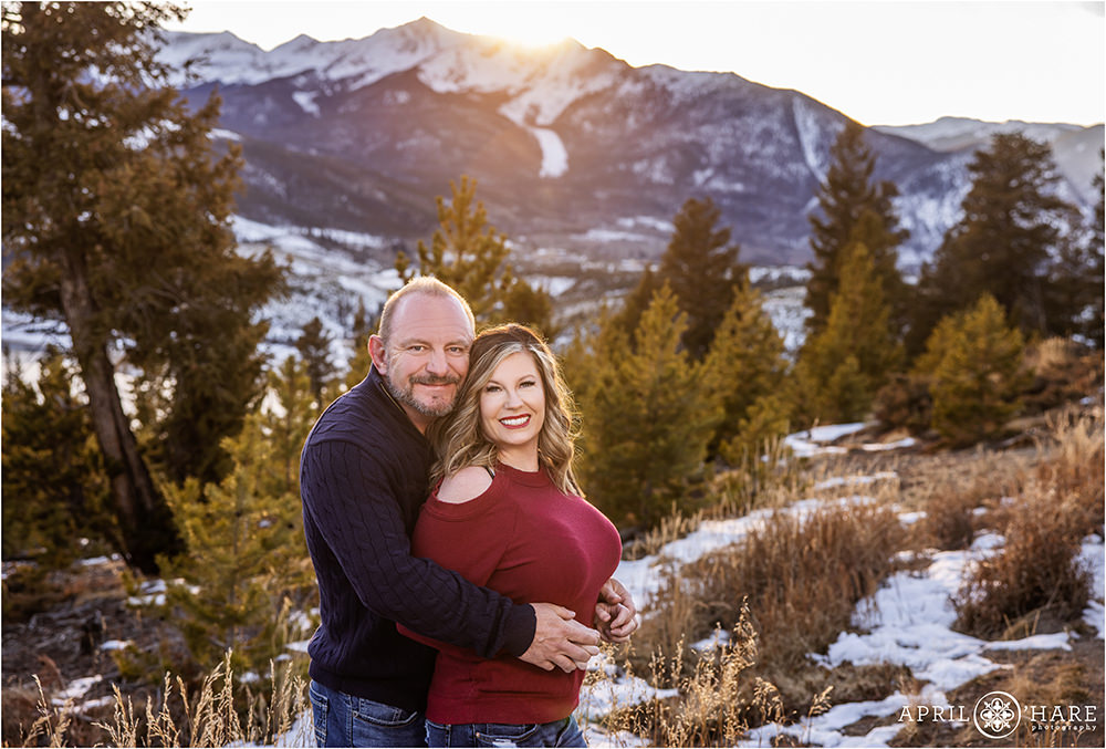 Couples portrait in front of the Ten Mile Mountain Range at Sapphire Point as the sun sets on a cold winter day in Colorado