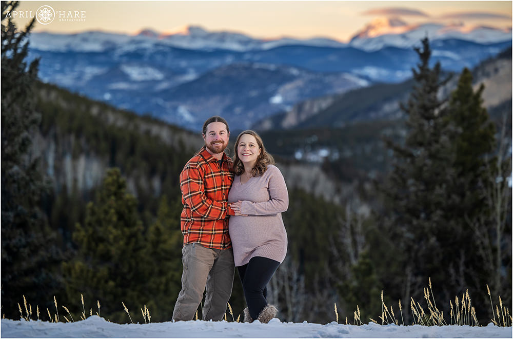 Gorgeous maternity photo in front of a pretty sunset mountain backdrop on Squaw Pass Road in Evergreen