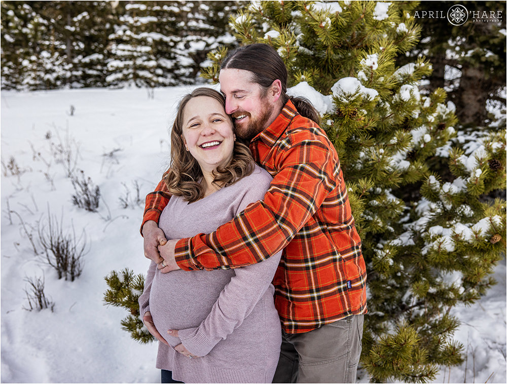 Candid portrait of a couple cudding at their maternity photography session in the woods of Evergreen Colorado