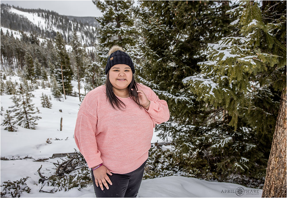 Snowy winter portrait for a woman wearing a pink sweater at Sapphire Point in Colorado