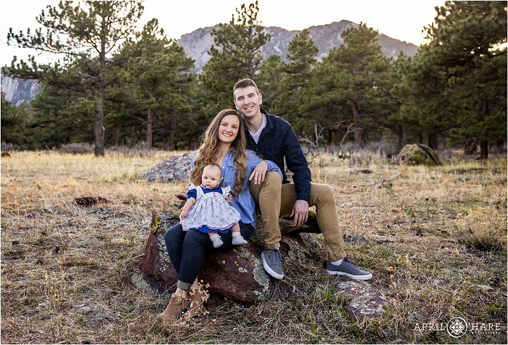 Young couple with a baby pose in a mountain forest of Boulder Colorado