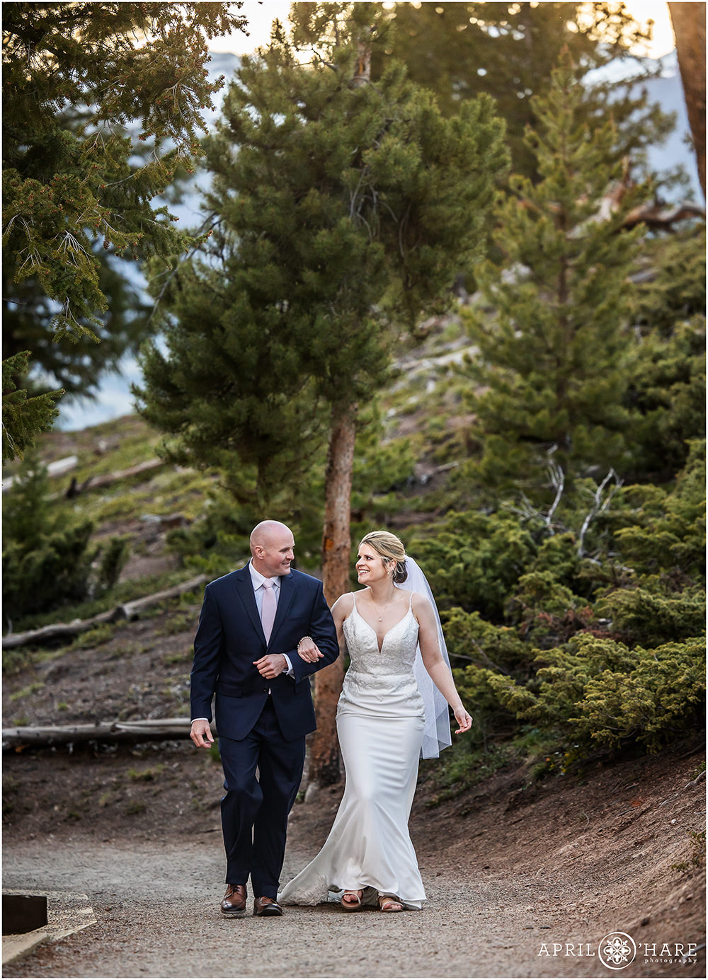 Couple walk up the path way surrounded by evergreen trees at Sapphire Point in Colorado