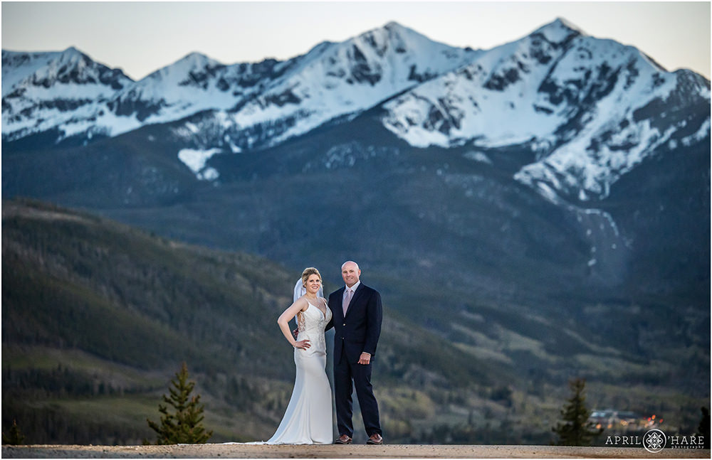 Bride and groom pose for a cool portrait at dusk with a huge mountain backdrop behind them at Sapphire Point