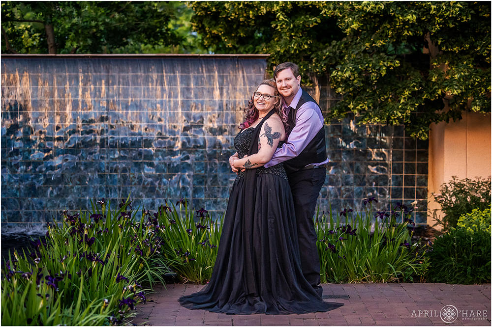 Couple stands next to blue tile fountain at Sunset at their Denver Botanic Gardens engagement photoshoot