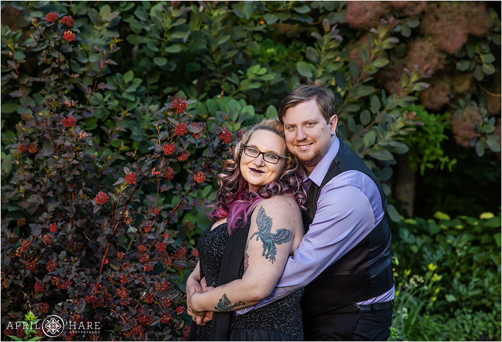 Dark plant backdrop at Denver Botanic Gardens for a couple wearing purple and dark clothing