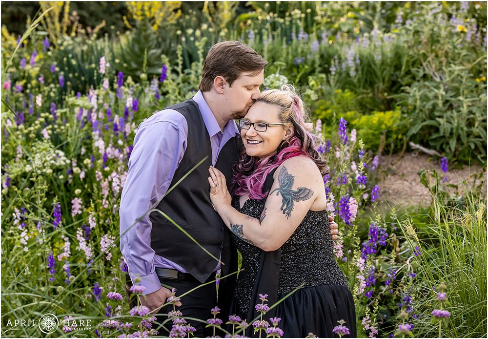 Couple surrounded by purple plants snuggle at their engagement photo session at Denver Botanic Gardens