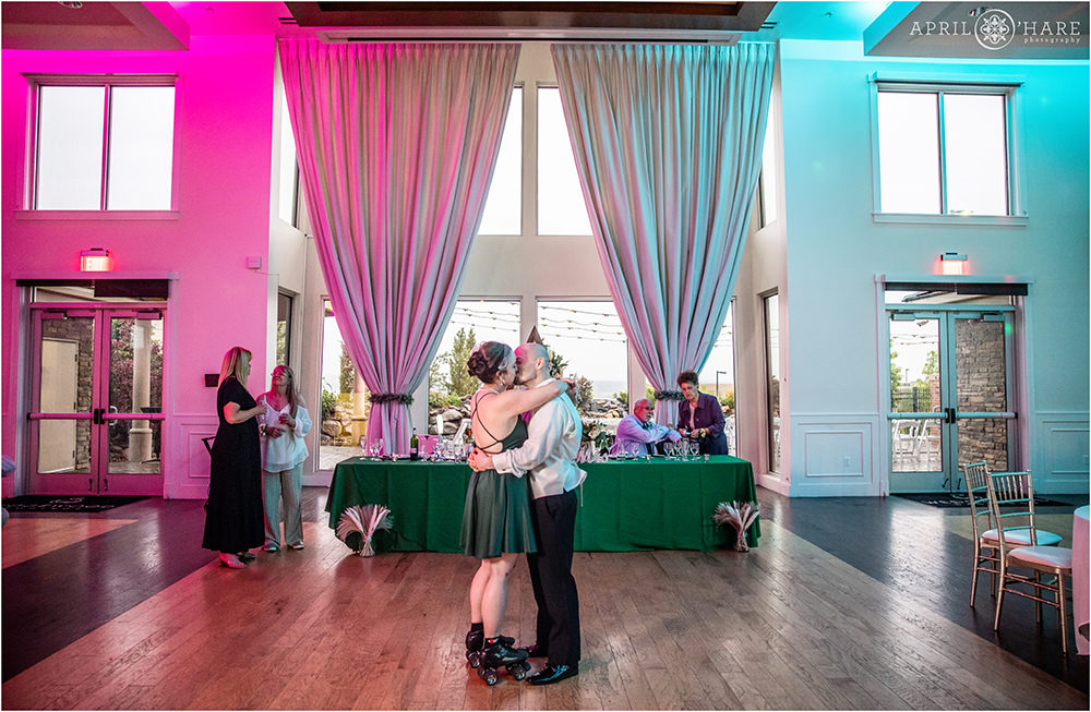 A woman wearing a cute short flared green dress with an open back kisses her husband of 20 years on the dance floor at their vow renewal celebration in Colorado