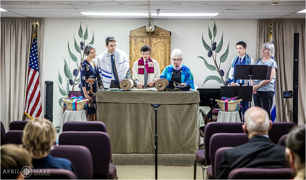 Family stands with bar mitzvah boy as he reads from the Torah at his Synagogue in Lakewood Colorado