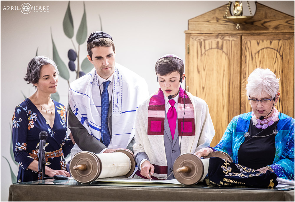 Parents stand with this son as he reads from the Torah on the day of his bar mitzvah in Colorado