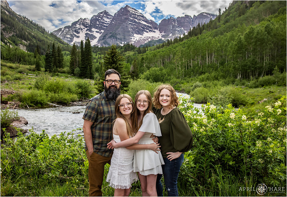 Family of 4 pose in front of the incredible Maroon Bells mountain views near Aspen Colorado