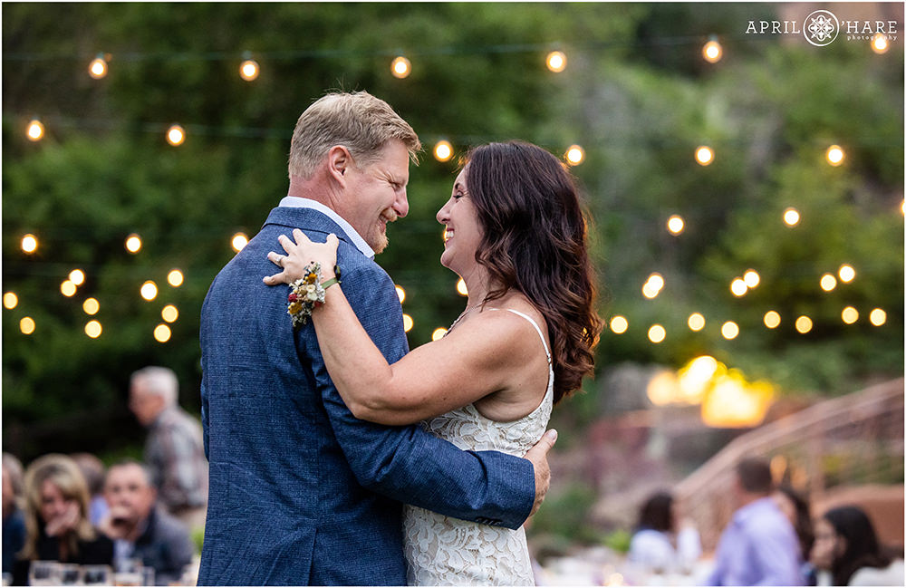 Bride and Groom Dance with the String Lights in the backdrop at Red Rocks Trading Post Backyard in Colorado